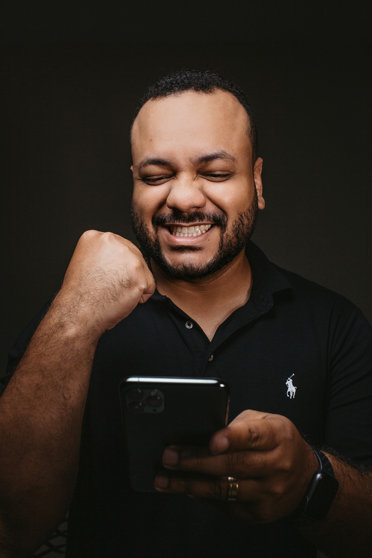 Happy young ethnic man enjoying success